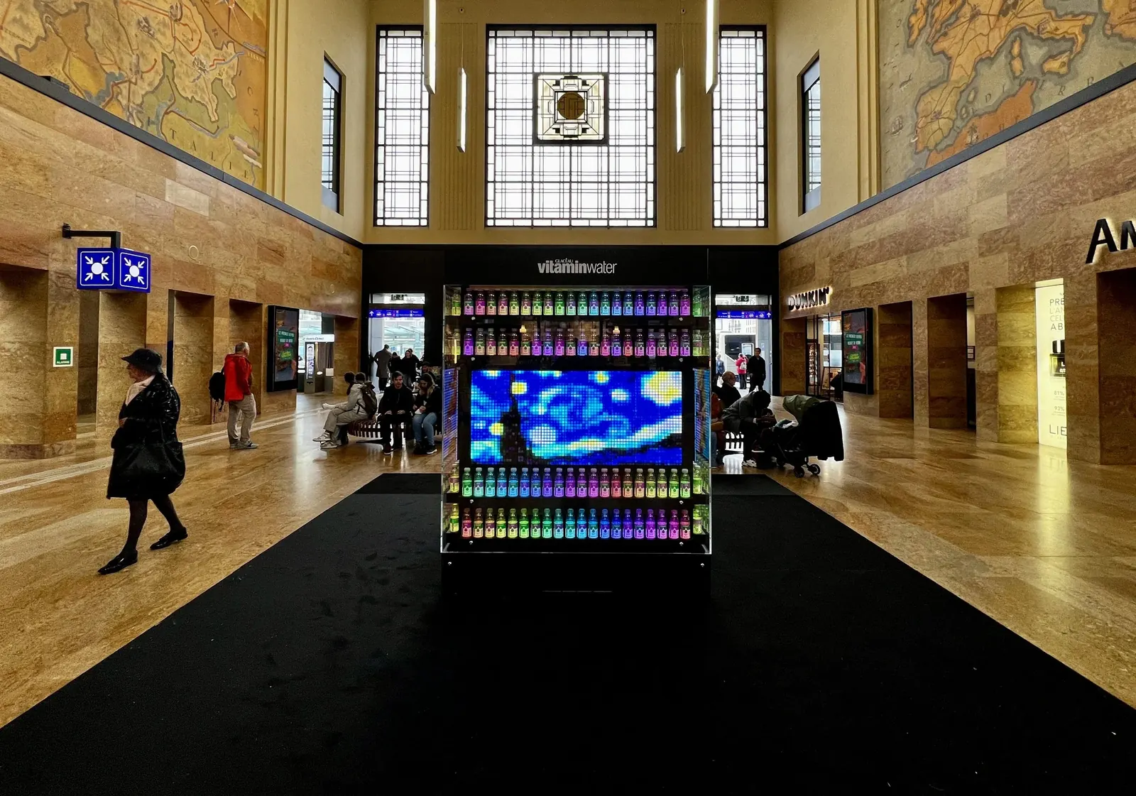 Le VITACUBE éclairé en soirée dans le hall de gare